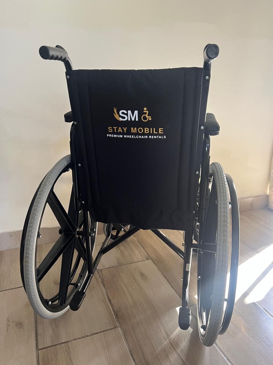 A folding Stay Mobile wheelchair, branded on the backrest.